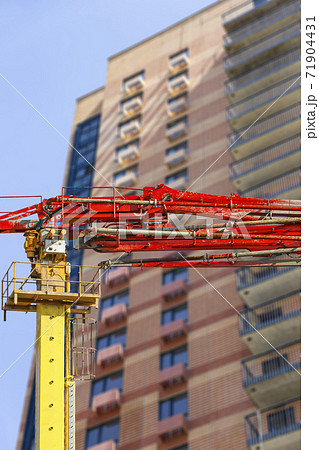 Construction concrete pump (pump truck ) with multi-storey building under construction (new residential complex) on the background, Moscow, Russia Construction concrete pump (pump truck ) with multi-storey building under construction (new residential complex) on the background, Moscow, Russia 71904431
