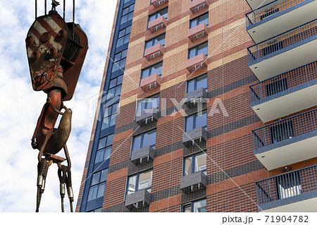 Construction crane hook with multi-storey building under construction (new residential complex) on the background. Construction site upon renovation program in Cheryomushki district, Moscow, Russia 71904782