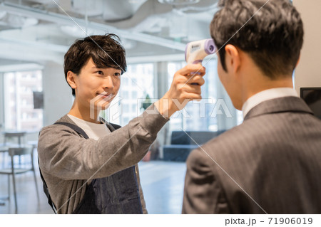 来店者の検温を行うスタッフ 来店者の検温を行うスタッフ 71906019