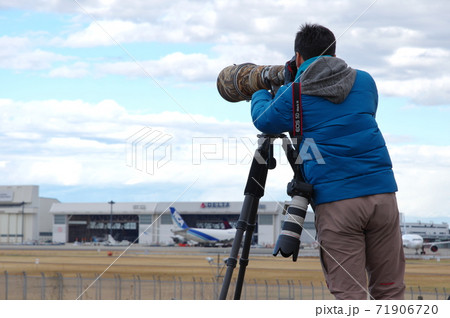 超望遠レンズで飛行機を狙うカメラマン 71906720