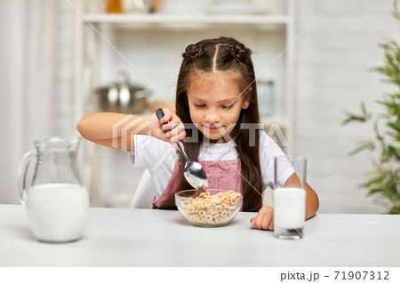 cute little girl eating breakfast: cereal with the milk cute little girl eating breakfast: cereal with the milk 71907312