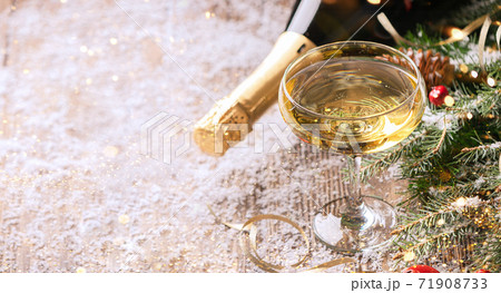 A glass of sparkling wine champagne a bottle close-up a festive Christmas table 71908733