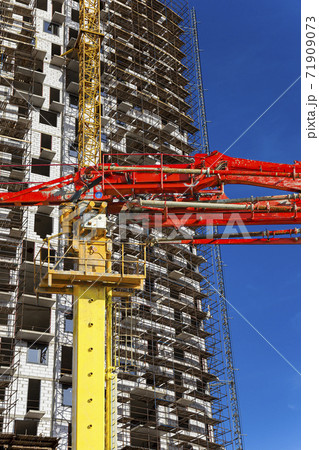 Construction concrete pump (pump truck) with multi-storey building under construction with scaffolding (new residential complex) on the background, Moscow, Russia Construction concrete pump (pump truck) with multi-storey building under construction with scaffolding (new residential complex) on the background, Moscow, Russia 71909073