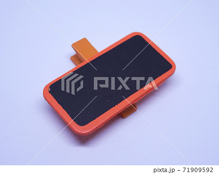 Wooden cloth clip attached with small empty black board on it isolated on white background. 71909592