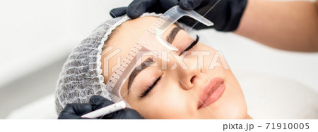 Beautician measuring brows with ruler 71910005