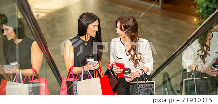 Two girlfriends going up the escalator 71910015