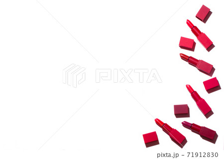Group of red lipsticks spread on a white background. On the right is a place for an inscription. 71912830