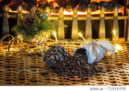 Cone and pine nuts on the braided surface. Christmas tree and lights. Cone and pine nuts on the braided surface. Christmas tree and lights. 71914356