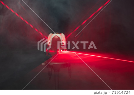 laser level tool red light beams in smoke 71914724