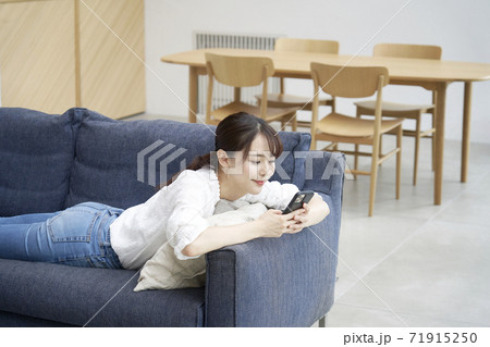 リビングでスマホを使う女性 71915250