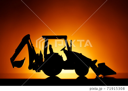 backhoe tractor silhouette, orange sunset background backhoe tractor silhouette, orange sunset background 71915308