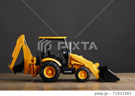 backhoe tractor toy, gray background backhoe tractor toy, gray background 71915365