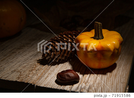 composition of cones, pumpkins and chestnuts that stand on wooden table 71915586