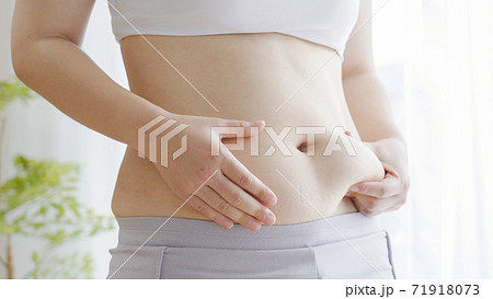 お腹の肉を摘む女性 71918073
