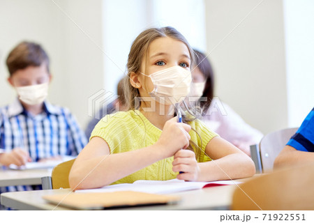little student girl in mask on lesson at school 71922551