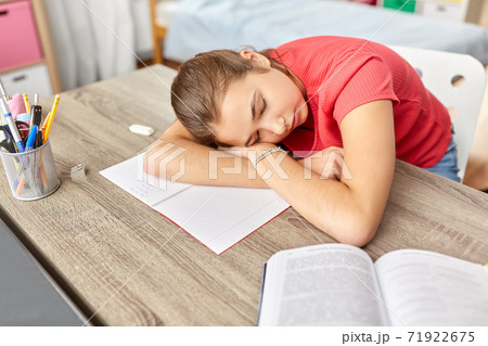 tired student girl sleeping on table at home tired student girl sleeping on table at home 71922675