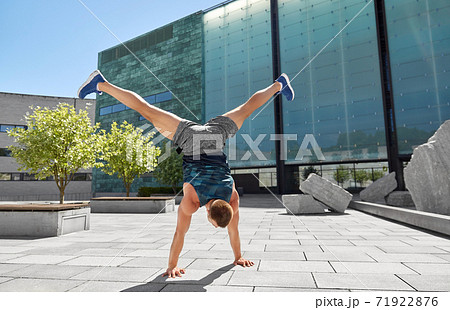 young man exercising and doing handstand outdoors young man exercising and doing handstand outdoors 71922876