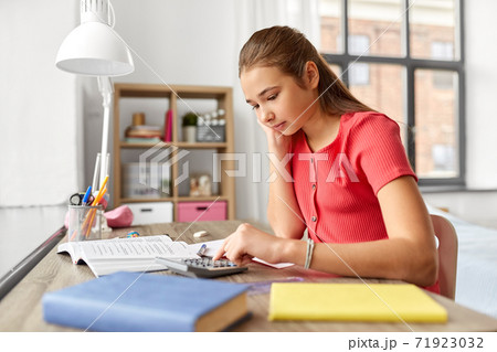 student girl counting on calculator at home student girl counting on calculator at home 71923032