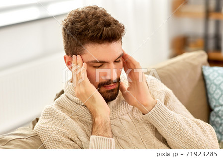unhappy man suffering from head ache at home unhappy man suffering from head ache at home 71923285