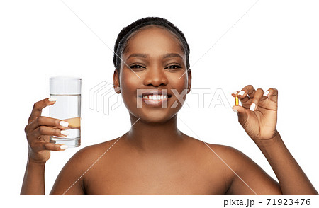 african woman with cod liver oil and water glass 71923476