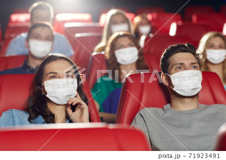 people in masks watching movie in theater people in masks watching movie in theater 71923491