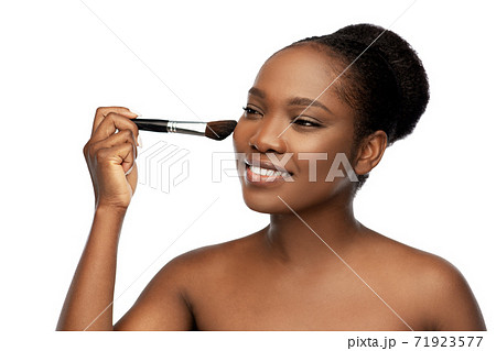 woman with make up brush applying blush to face 71923577