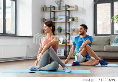 happy couple exercising at home 71923899