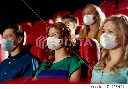 people in masks watching movie in theater 71923901
