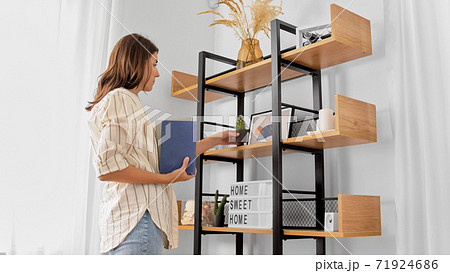 woman arranging flower and books at home woman arranging flower and books at home 71924686