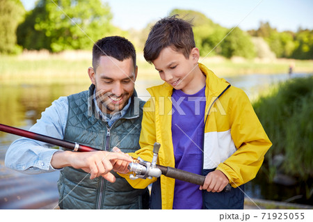 happy smiling father and son fishing on river happy smiling father and son fishing on river 71925055