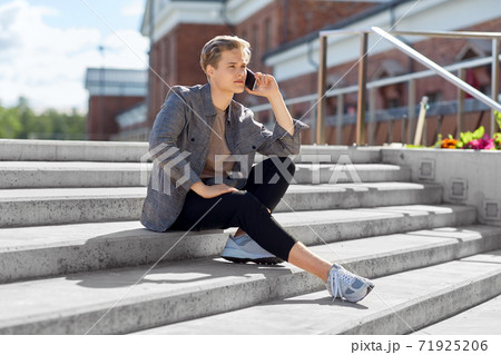 teenage boy calling on smartphone in city teenage boy calling on smartphone in city 71925206