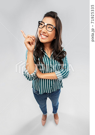 smiling asian student woman pointing finger up smiling asian student woman pointing finger up 71925335