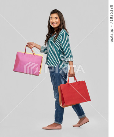 happy asian woman walking with shopping bags happy asian woman walking with shopping bags 71925339