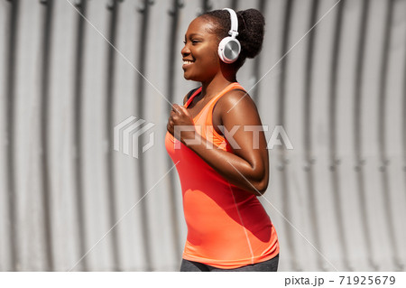 happy african american woman running outdoors happy african american woman running outdoors 71925679