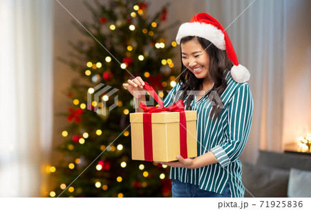 Asian elderly woman opening a gift or present at Christmas. Happy