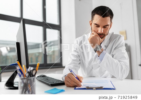 stressed male doctor with clipboard at hospital stressed male doctor with clipboard at hospital 71925849