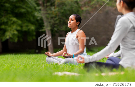 group of people doing yoga at summer park group of people doing yoga at summer park 71926278