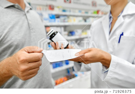 pharmacist and customer with medicine at pharmacy 71926375