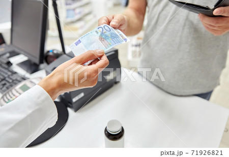 pharmacist taking money from customer at pharmacy pharmacist taking money from customer at pharmacy 71926821