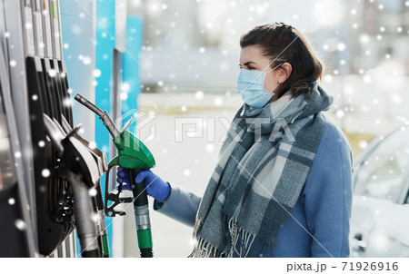 young woman wearing medical mask at gas station young woman wearing medical mask at gas station 71926916