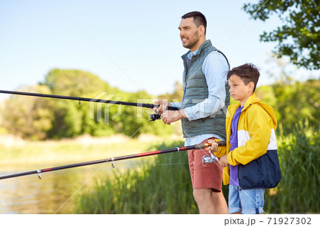 happy smiling father and son fishing on river happy smiling father and son fishing on river 71927302