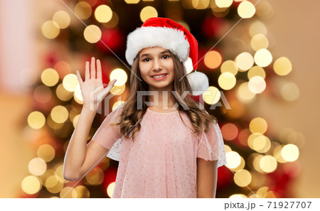 happy teenage girl waving hand on christmas 71927707