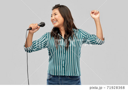 happy asian woman with microphone singing 71928368