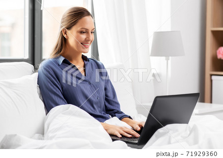 young woman with laptop in bed at home bedroom 71929360