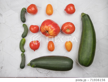 Ripe vegetables-tomatoes, zucchini and cucumbers are laid out on a light background. Horizontal orientation Ripe vegetables-tomatoes, zucchini and cucumbers are laid out on a light background. Horizontal orientation 71936156