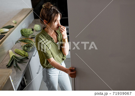 Woman looking into the fridge on the kitchen at home Woman looking into the fridge on the kitchen at home 71939067
