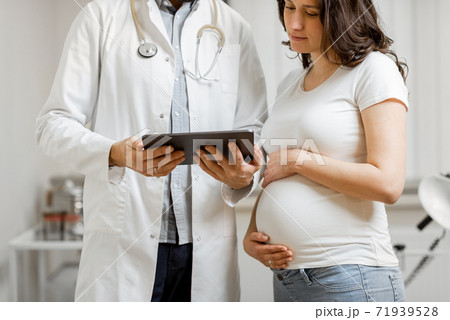 Doctor with pregnant woman during a medical consultation 71939528