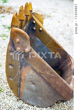 Excavator digger Backhoe bucket on construction site, gray crushed stone rubble background close up 71939807