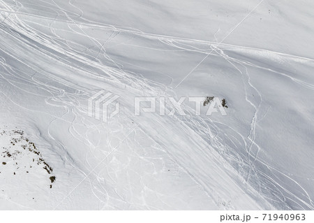 Snowy off-piste slope with traces of skis and snowboards Snowy off-piste slope with traces of skis and snowboards 71940963