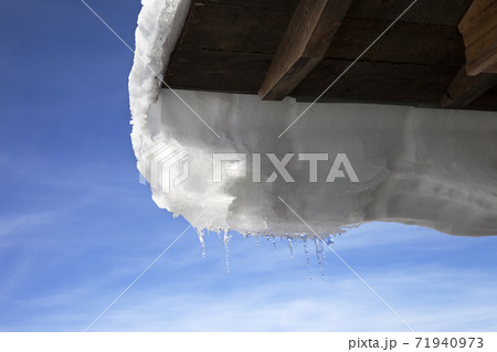 Wooden roof with snow cornice and icicle 71940973